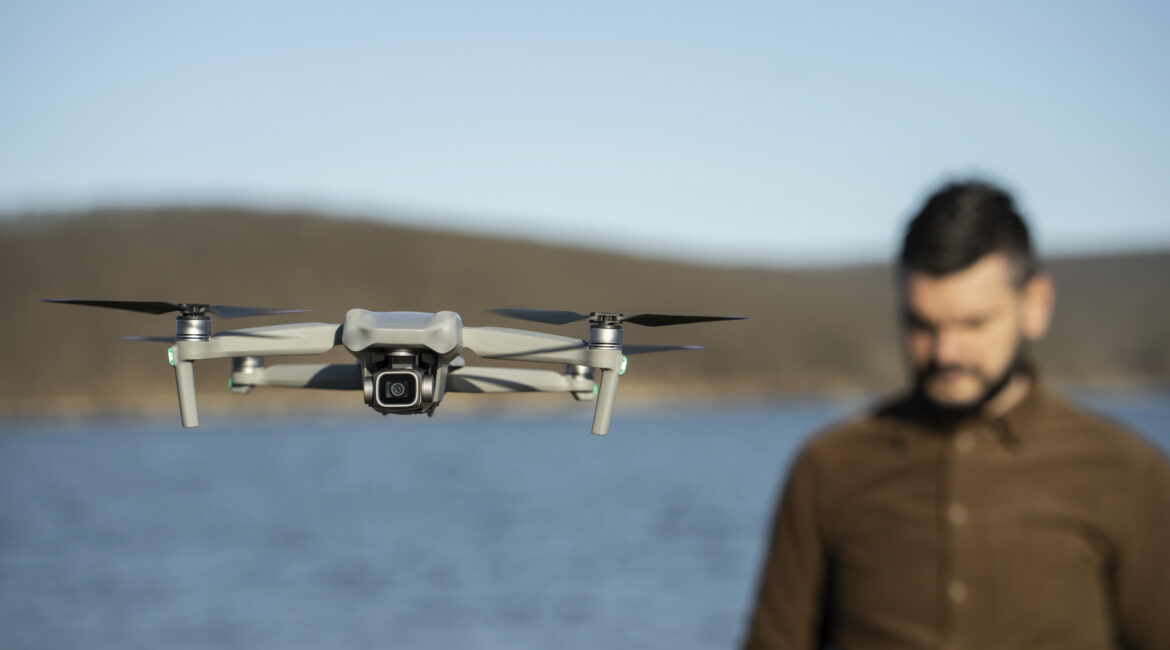 Monitoramento Inteligente: Como a Tecnologia Está Revolucionando a Segurança 1 homem embacado de tiro medio com drone ao ar livre